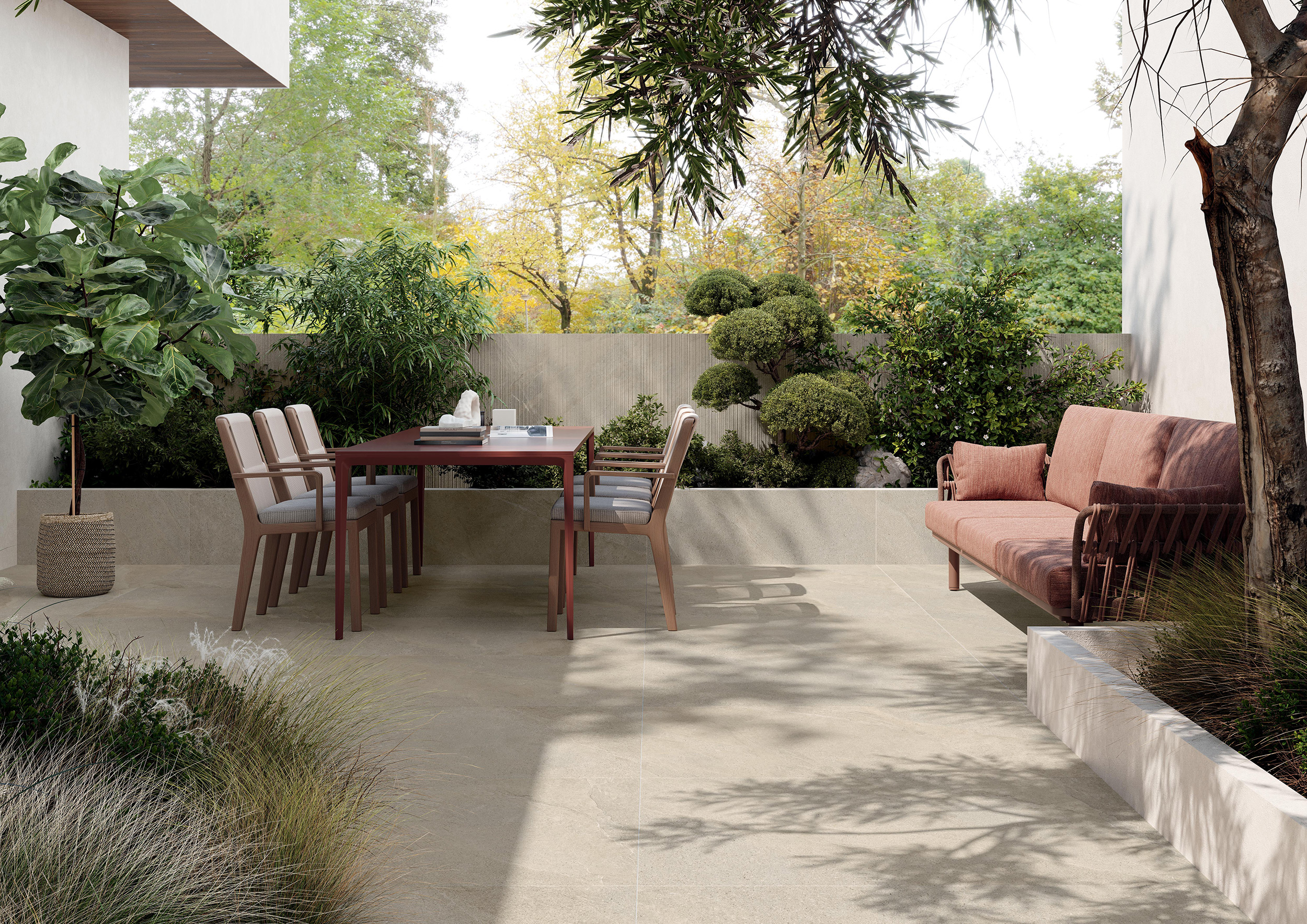 Terrasse mit hellen Großformat-Platten, Esstisch und Sitzbank vor einer Gartenmauer